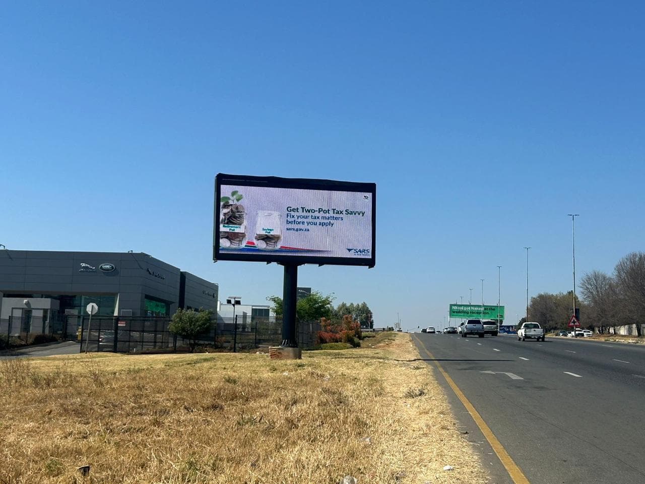 SARS "Get Two-Pot Tax Savvy" billboard beside a highway under a blue sky